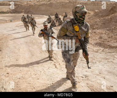 La Force iraquienne des gardes frontière effectue des patrouilles pour sécuriser le terrain et maintenir l'état de préparation opérationnelle. L'image d'archives documente des membres du 1er bataillon de la 12e brigade effectuant un exercice de patrouille d'escouade au camp Al Asad en mars 2018. Le tirage photographique historique contient des instructions pratiques sur les procédures coordonnées de mouvement au sol et de patrouille. Banque D'Images