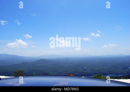 Ouvrir large vue sur les montagnes bleues avec ciel bleu dans une journée ensoleillée. Car top close up avec la réflexion du ciel bleu et bleu sur fond de montagnes Banque D'Images