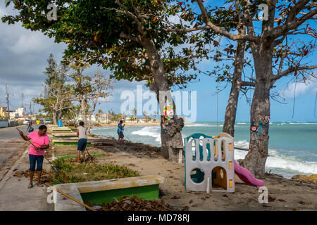 Comme la plupart des résidents de l'île, ceux qui vivent dans la ville côtière de Loiza, Puerto Rico se trouve toujours nettoyer après les tempêtes. Non seulement l'Ouragan Maria endommagé la ville, mais il a détruit les barrières naturelles qui empêchent les eaux de la hausse sans cesse et endommager les routes de la côte. Banque D'Images