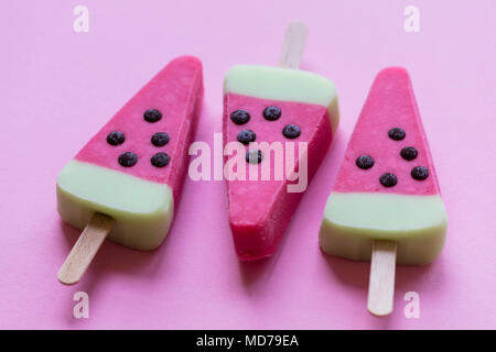 Melon d'été en forme de sucette de glace sur un fond rose pastel Banque D'Images