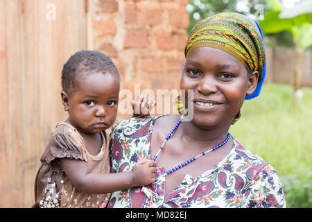 Lugazi, en Ouganda. 09 juin 2017. Une heureuse et souriante jeune femme africaine tenant son enfant dans ses bras. Banque D'Images