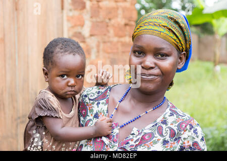 Lugazi, en Ouganda. 09 juin 2017. Une heureuse et souriante jeune femme africaine tenant son enfant dans ses bras. Banque D'Images