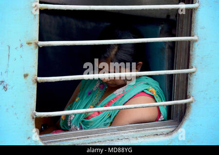 Femme aslee vu à travers la fenêtre d'un train indien Banque D'Images