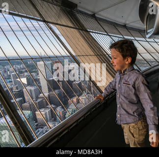 Boy admiring Toronto cityscape à partir de la fenêtre, Canada Banque D'Images