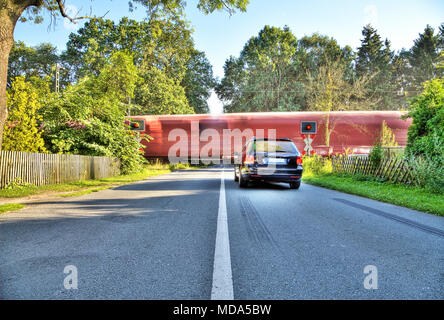 Voiture bleue se trouve en face d'un passage ferroviaire allemand Banque D'Images