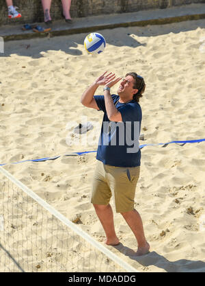 Brighton UK 19 avril 2018 - James d'argent, connu sous le nom de beach-volley joue Arg sur le front de mer de Brighton avec extras de la télé-réalité show 'le seul moyen est l'Essex' comme ils aiment le beau temps ensoleillé pendant le tournage . Le beau temps chaud est appelée à se poursuivre tout au long de la Grande-Bretagne avec les températures devraient atteindre dans les années 20 élevée dans certaines parties du sud-est Crédit : Simon Dack/Alamy Live News Crédit : Simon Dack/Alamy Live News Banque D'Images