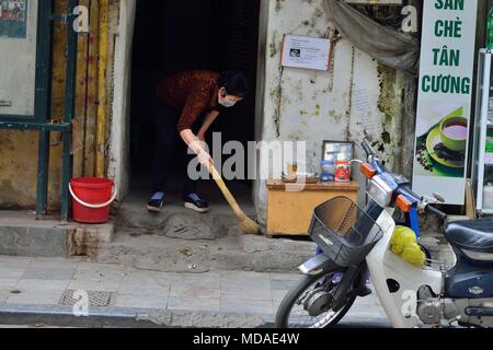 Hanoi, Vietnam. Apr 15, 2018. Une femme balaie sa porte dans l'ancienne Qurter de Hanoi, Vietnam. Credit : Rory joyeux/ZUMA/Alamy Fil Live News Banque D'Images