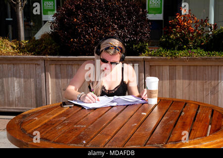 Tayside, Dundee, Ecosse, Royaume-Uni. 19 avril, 2018. Météo France : Sex Spanish Plume déferle sur l'Amérique du Nord Est de l'Écosse avec des températures qui atteignent 20 °C ; devenir le printemps le plus chaud depuis des décennies. Un jeune élève assis à étudier tout en écoutant de la musique à partir de son téléphone mobile à la place d'une table de pique-nique sur une chaude journée ensoleillée d'avril à Dundee. UK. Credit : Dundee Photographics / Alamy Live News Banque D'Images