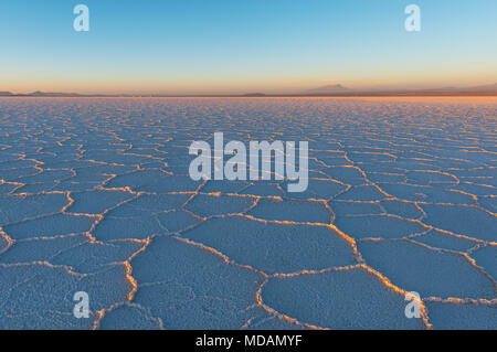 Coucher du soleil dans l'Uyuni salt flat (Salar de Uyuni) avec les derniers rayons du soleil qui brille sur les formations hexagonales minéral, la Bolivie, l'Amérique du Sud. Banque D'Images