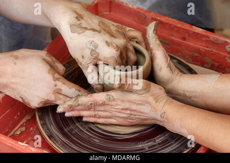 Mains de deux personnes créent sur pot de potier. L'enseignement de la poterie, carftman directeurs les mains Banque D'Images