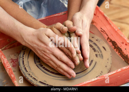 Mains de deux personnes créent sur pot de potier. L'enseignement de la poterie, carftman directeurs les mains Banque D'Images