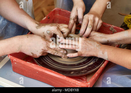 Mains de trois personnes créer sur pot de potier. L'enseignement de la poterie, carftman directeurs les mains Banque D'Images