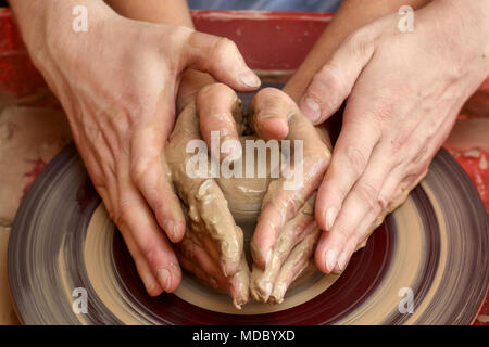 Mains de deux personnes créent sur pot de potier. L'enseignement de la poterie, carftman directeurs les mains Banque D'Images
