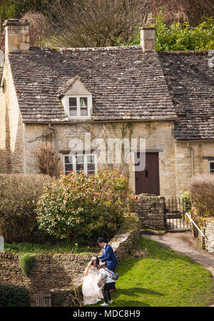 Asian Bride and Groom posent pour les photographies de mariage dans le village de Cotswold Anglais Bibury Gloucestershire Banque D'Images