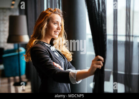 Glamorous woman staring through window Banque D'Images