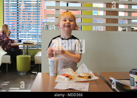 Un petit garçon, le petit-déjeuner à Mc Donald's à Llandudno Banque D'Images