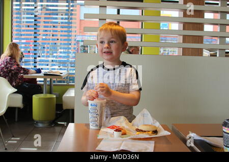 Un petit garçon, le petit-déjeuner à Mc Donald's à Llandudno Banque D'Images