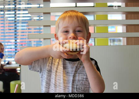 Un petit garçon, le petit-déjeuner à Mc Donald's à Llandudno Banque D'Images