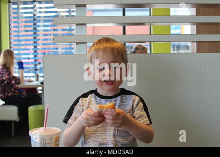 Un petit garçon, le petit-déjeuner à Mc Donald's à Llandudno Banque D'Images