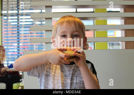 Un petit garçon, le petit-déjeuner à Mc Donald's à Llandudno Banque D'Images