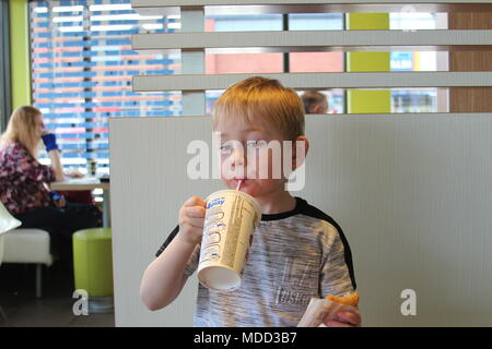 Un petit garçon, le petit-déjeuner à Mc Donald's à Llandudno Banque D'Images