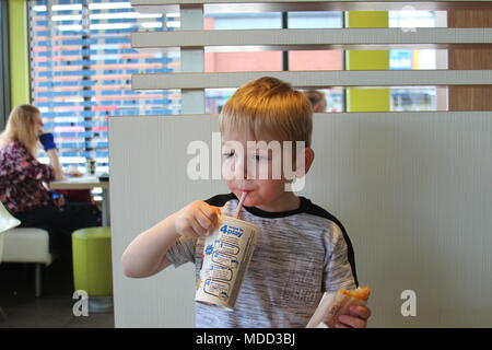 Un petit garçon, le petit-déjeuner à Mc Donald's à Llandudno Banque D'Images