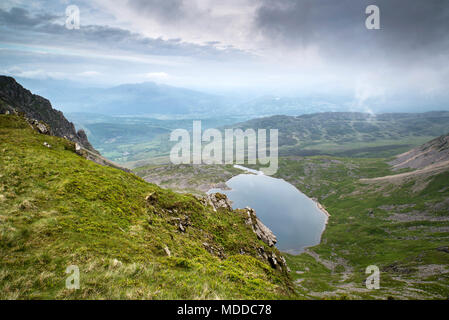 À la recherche du haut de la montagne Cadair Idris dans le parc national de Snowdonia sur Llyn y Gader avec ciel nuageux ciel d'orage. Banque D'Images