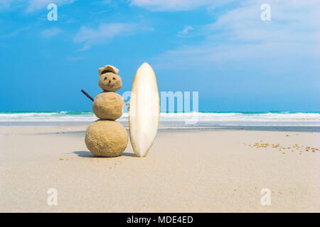 Sandman avec arrière-plan bleu de la mer. Sable jaune fait main surfer holding a white surf board sur une plage propre d'une île exotique. Le concept de l'ex Banque D'Images