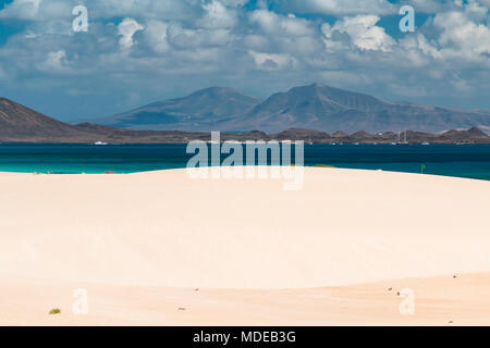 Vue sur la célèbre Corralejo dunes de sable à la plage Playa Larga à Fuerteventura, Espagne Lanzarote avec en arrière-plan. Banque D'Images