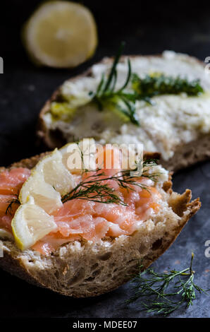 Les sandwichs au fromage à la crème et saumon sur surface métallique foncé Banque D'Images