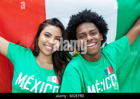 Rire les amateurs de soccer du Mexique avec drapeau mexicain en plein air au stadium Banque D'Images