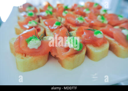 Belle entrée, fusion food, saumon fumé sur baguette avec de la mayonnaise et tobiko vert (oeufs de poisson volant) Banque D'Images