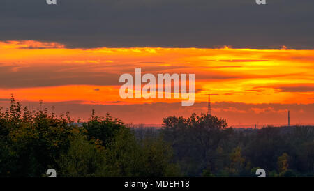 Coucher du soleil orange énergique magique avec la Tour Radio de Gliwice dans l'arrière-plan à Zabrze, Silésie, Pologne. Banque D'Images