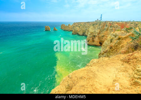 Côte de l'Algarve spectaculaire avec le phare de Ponta da Piedade dans la distance. Lagos, Algarve au Portugal. Tour Tourisme dans l'océan Atlantique. Vue aérienne de rock formation et piliers de la baie de Lagos. Banque D'Images