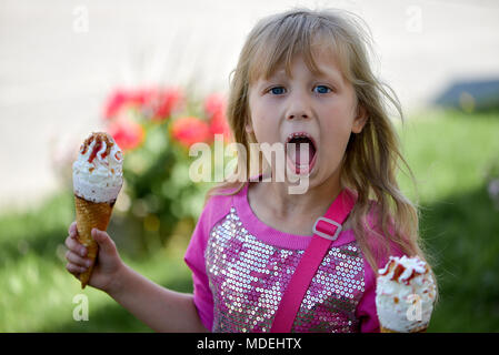 Woman's hands holding melting ice cream cornet gaufré dans les mains sur la lumière d'été nature background Banque D'Images