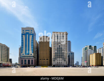 Sharjah, ÉMIRATS ARABES UNIS - 8 avril. En 2018. Quartier résidentiel de plusieurs étages et les immeubles de bureaux avec du sable en premier plan Banque D'Images