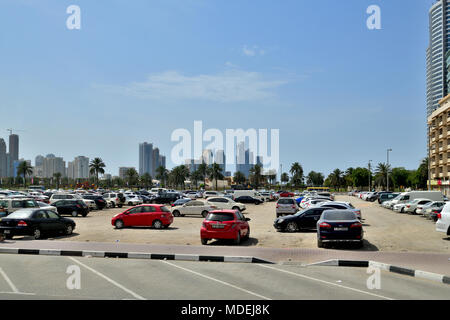 Sharjah, ÉMIRATS ARABES UNIS - 8 avril. En 2018. Parking gratuit dans le sable à côté d'immeubles de bureaux et résidentiels Banque D'Images