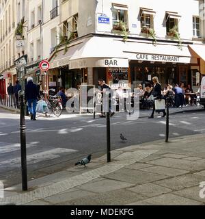 Les gens assis dans un café tandis que d'autres passent sur la rue dans le Marais, Paris, France. Banque D'Images