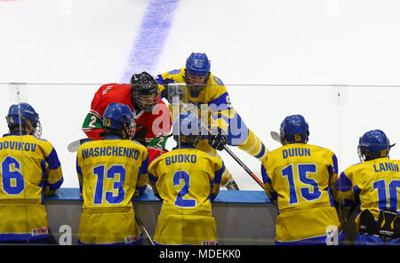Kiev, UKRAINE - le 17 avril 2018 : les joueurs ukrainiens sur banc observe tandis que L.KERESZTES de Hongrie (L) lutte pour une rondelle avec B.SEREDNITSKYY de l'Ukraine Banque D'Images