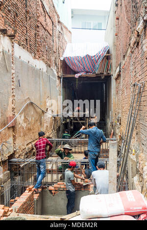 Ouvriers vietnamiens sur un petit chantier de pose de briques faisant un coffrage pour le sous-sol d'un bâtiment à Ho Chi Minh City, Vietnam. Banque D'Images