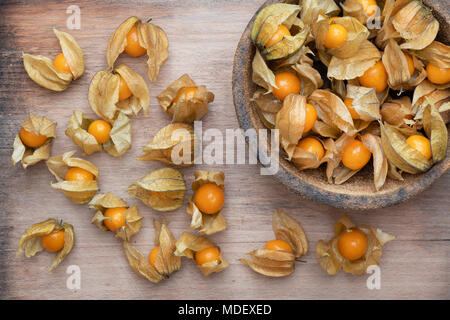 Physalis peruviana. Physalis les fruits dans un bol sur une planche en bois Banque D'Images