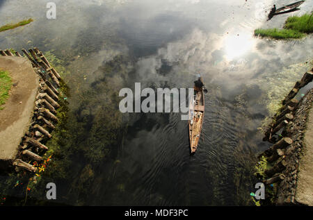 Srinagar, Inde. Apr 19, 2018. Un homme Cachemire rangées sur son bateau un matin ensoleillé à Srinagar, au Cachemire le 19 avril 2018.Le temps de l'autre côté de la vallée est l'amélioration continue de cette tempête d'après avoir passé quelques jours. Le Département météorologique du Cachemire avait déjà prédit cette tempête d'intensité modérée à forte dans toute la vallée du Cachemire. Credit : Faisal Khan/Pacific Press/Alamy Live News Banque D'Images