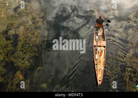 Srinagar, Inde. Apr 19, 2018. Un homme Cachemire rangées sur son bateau un matin ensoleillé à Srinagar, au Cachemire le 19 avril 2018.Le temps de l'autre côté de la vallée est l'amélioration continue de cette tempête d'après avoir passé quelques jours. Le Département météorologique du Cachemire avait déjà prédit cette tempête d'intensité modérée à forte dans toute la vallée du Cachemire. Credit : Faisal Khan/Pacific Press/Alamy Live News Banque D'Images