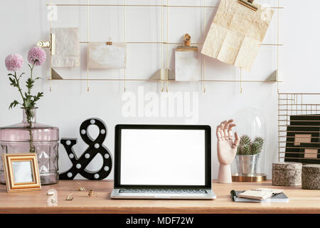 Ordinateur portable avec écran de la maquette, cadre doré et créatif organisateur notes décorations sur un bureau en bois dans un espace de travail intérieur hipster Banque D'Images