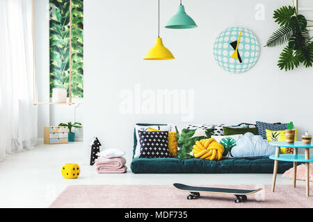 Skateboard sur rose tapis chambre d'enfant colorée intérieur avec des coussins sur les lampes matelas sous vert Banque D'Images