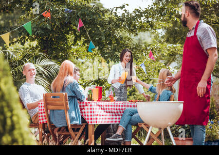 Groupe d'amis gais et de faire la fête ensemble de cuisson dans le jardin Banque D'Images