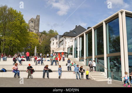 Les touristes sont au soleil devant les ruines du château de Drachenfels et le restaurant moderne Banque D'Images