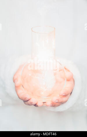 Boy holding un bocal de verre rempli d'étincelles électriques Banque D'Images