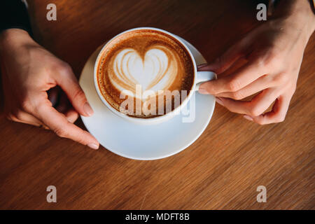 Woman's hand holding un cappuccino Banque D'Images