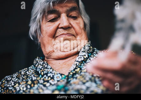 Close up of finger d'une vieille femme est de la laine à tricoter de sécheresse naturelle laine de mouton (en fibres naturelles) sur le mode traditionnel Banque D'Images